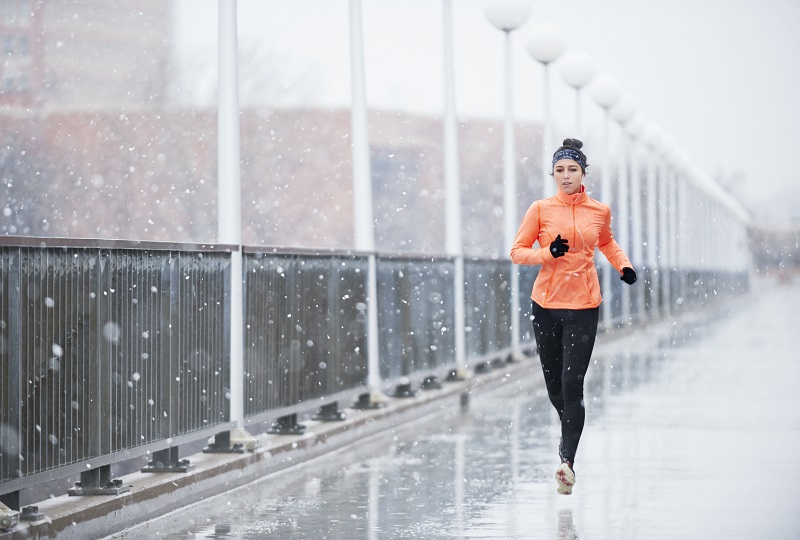 a woman running while it’s snowing