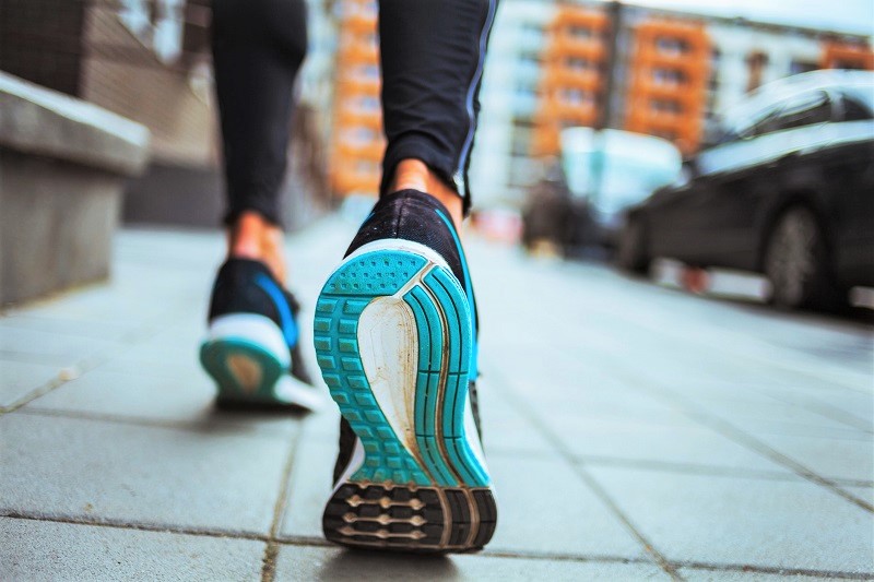 Woman mid-step on the street, with view of her shoe sole.