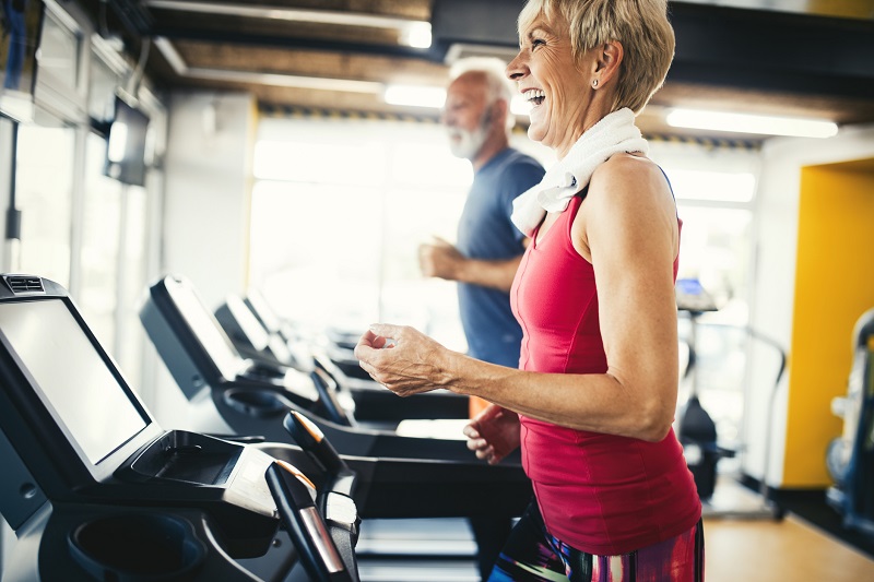 man and woman walking on a treadmill to burn more calories