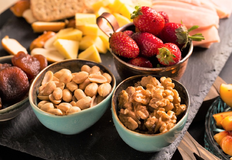 a close up of appetizers which include cheeses fruits and nuts