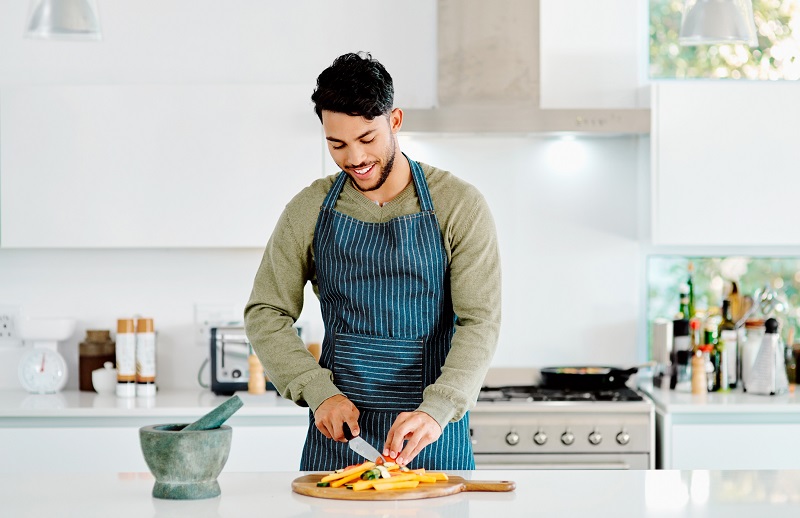 a man prepping healthy vegetables on the kitchen counter