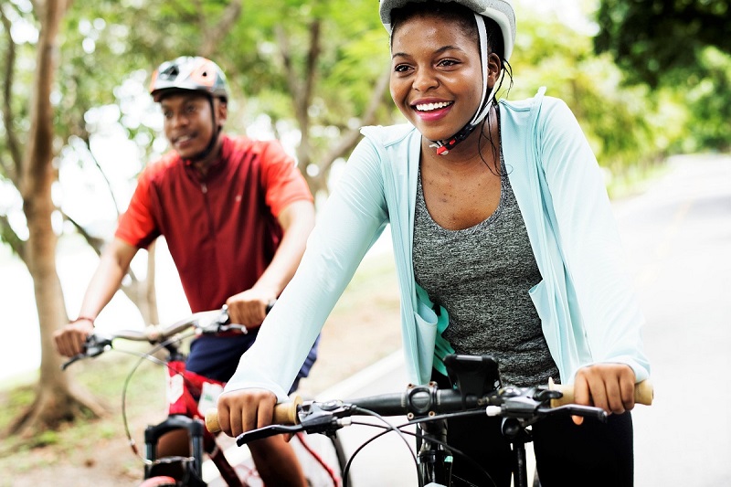 a young couple biking together in a park