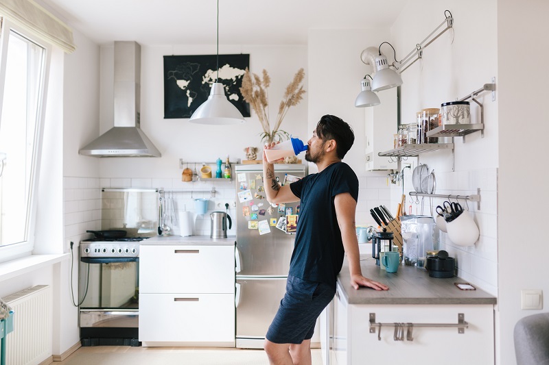 a man drinking protein shake in the kitchen for simple weight loss