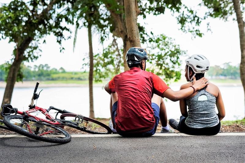 a father and daughter taking a break from cycling in a park