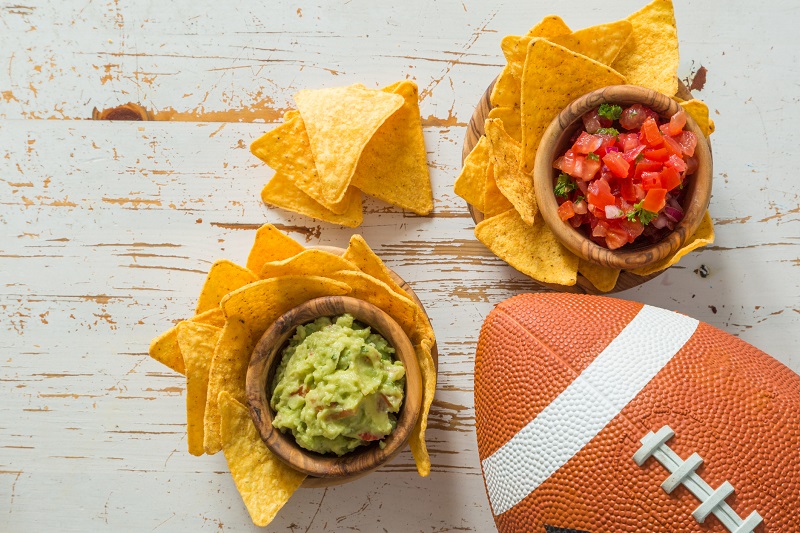 chips and dip on a table with a football